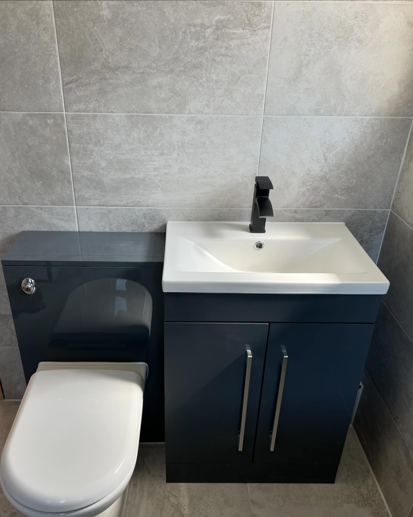 Modern fitted vanity unit and concealed toilet in new bathroom