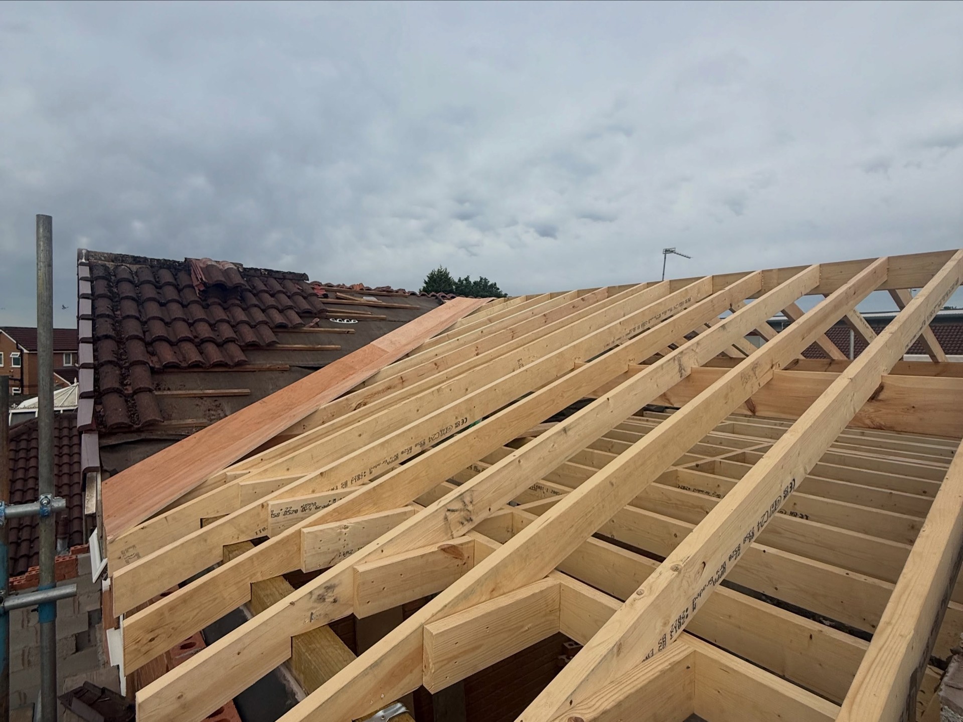 New loft roof structure being framed over existing house, aerial view
