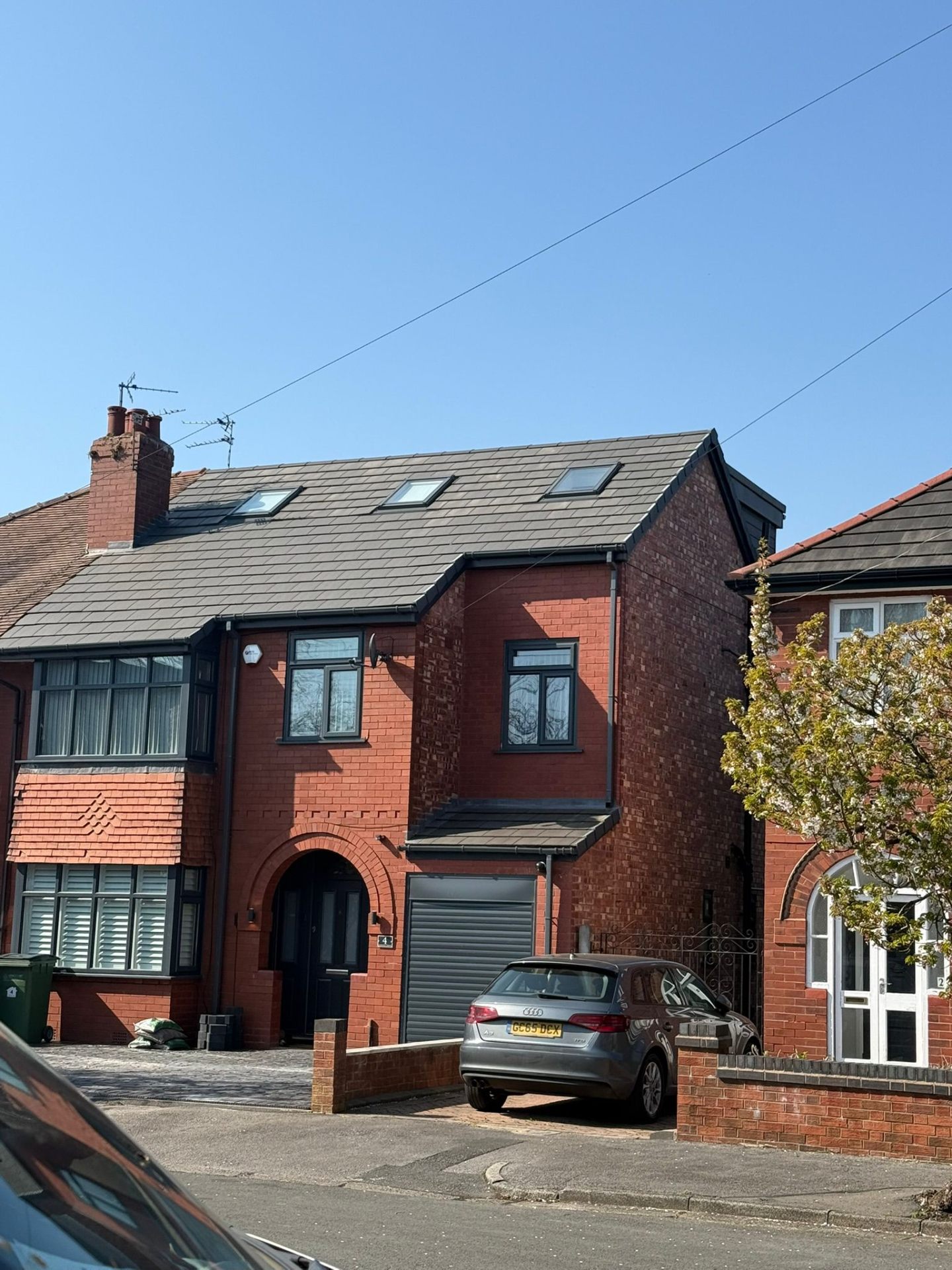 Red-brick side and rear loft extension with new slate-grey tiled roof and rooflights in Greater Manchester