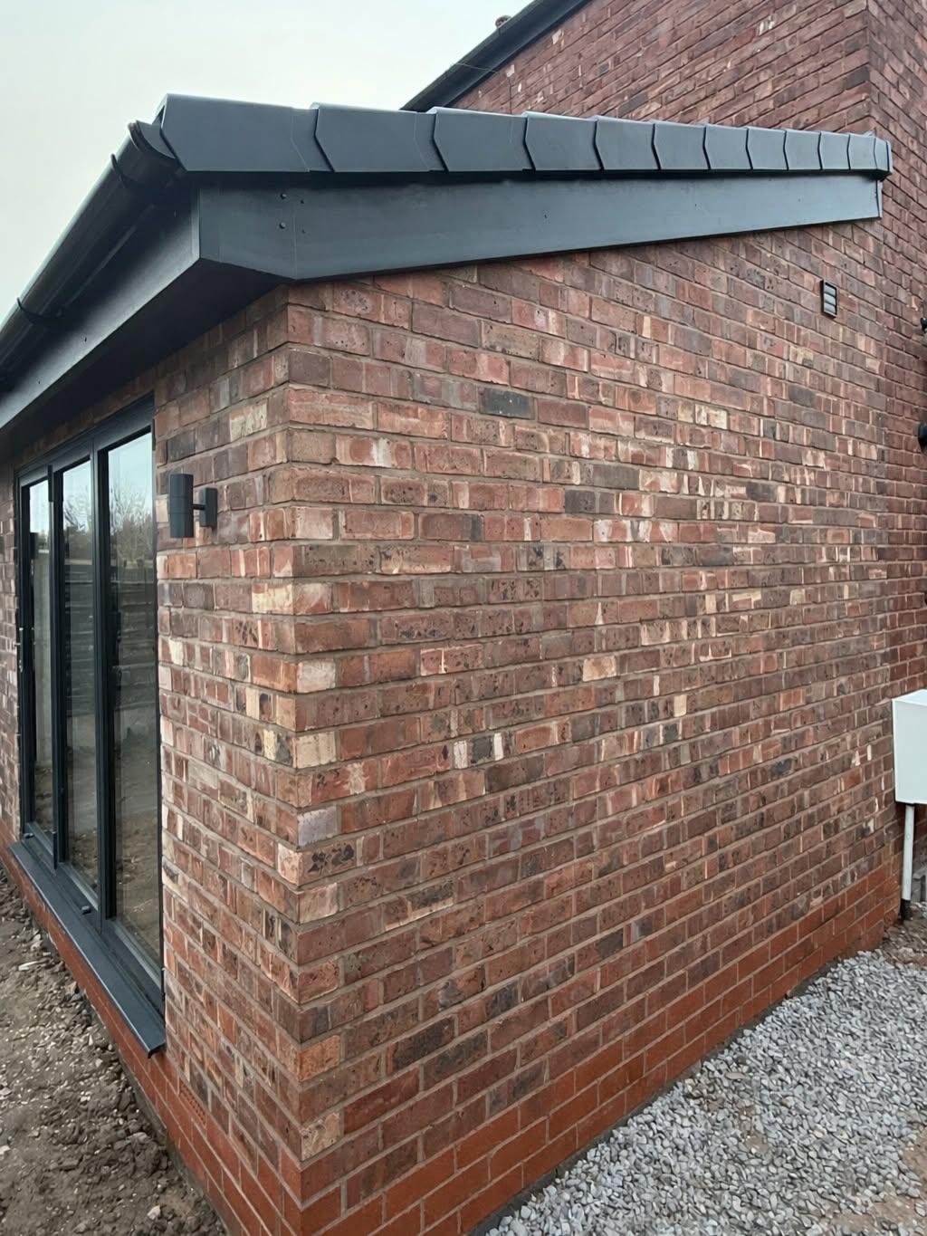 Brick extension with slate roof and tile creasing detail