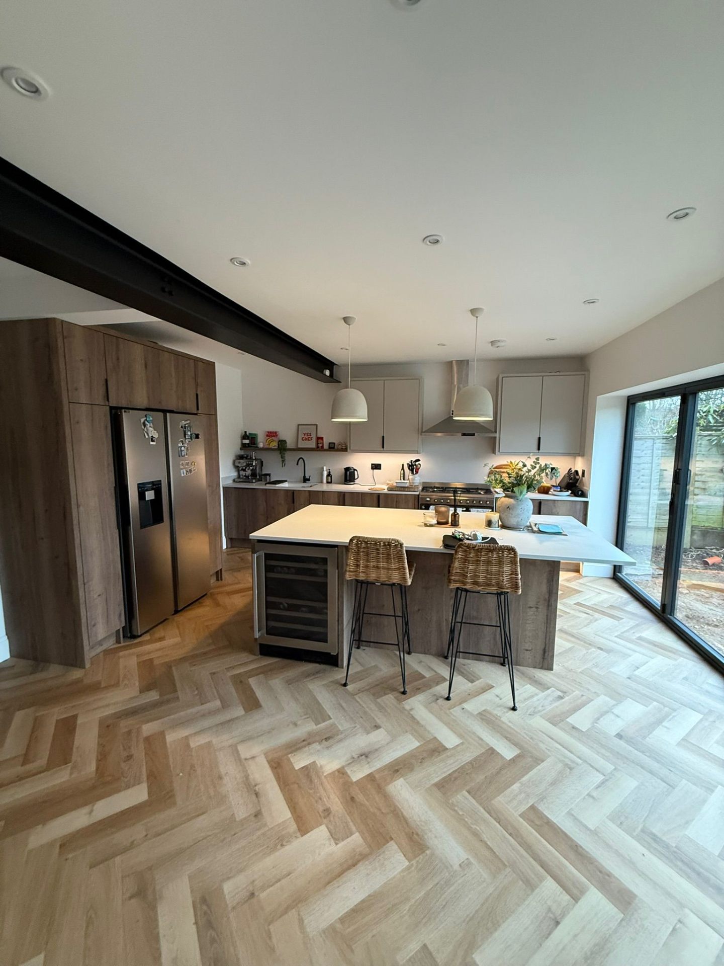 Completed kitchen refurbishment with island, integrated wine cooler and bifold doors to garden