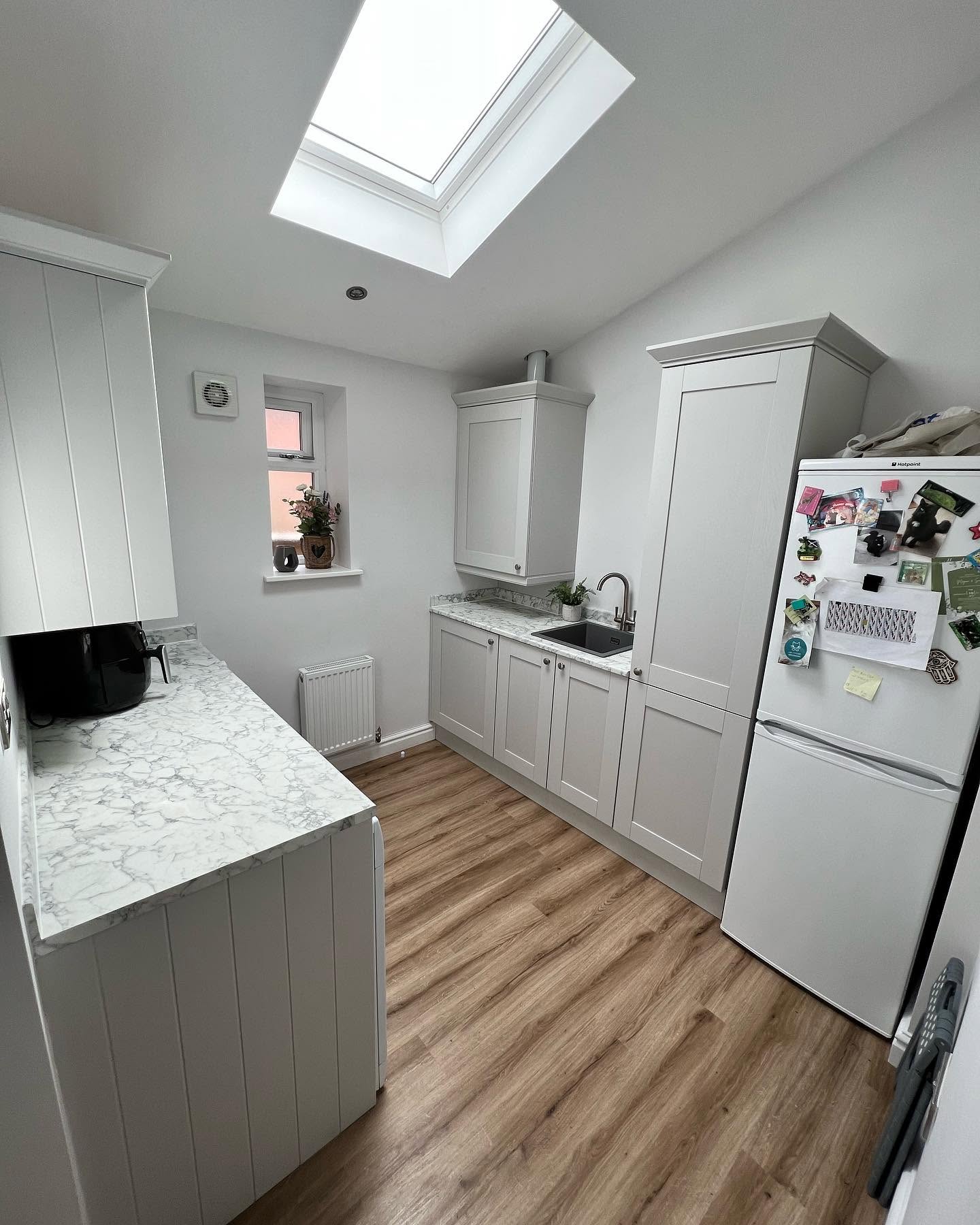 White Shaker kitchen with quartz island and bifold doors