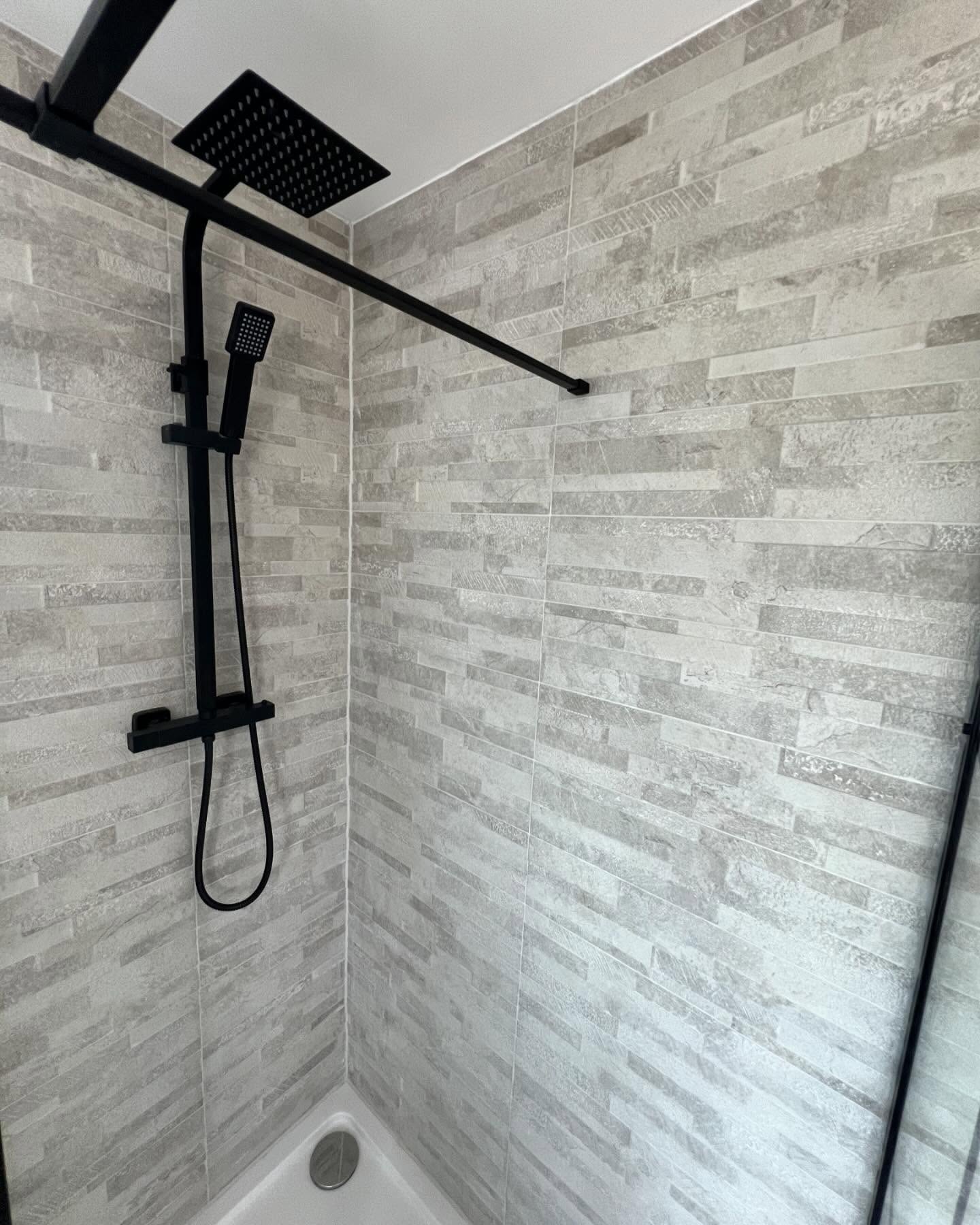 Walk-in shower with grey marble tiling in new bathroom